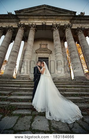 The Lovely Couple In Love Stand Near Coloums