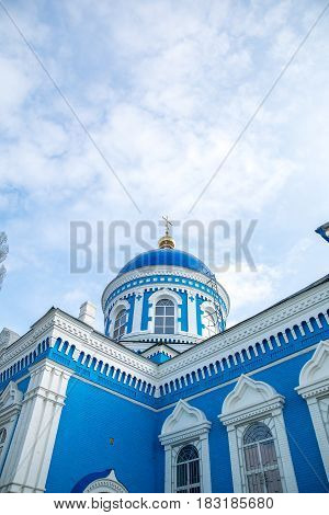 Old blue-white church with blue sky and clouds