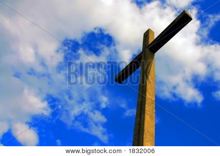 Cruz de cemento iluminada contra el cielo nublado