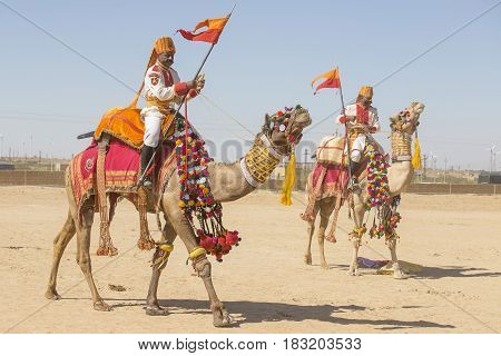 JAISALMER INDIA - FEBRUARY 09 2017 : Camel and indian men wearing traditional Rajasthani dress participate in Mr. Desert contest as part of Desert Festival in Jaisalmer Rajasthan India