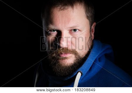 Solid bearded middle-aged man portrait on black background