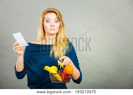 Worried Woman Holding Shopping Basket With Fruits