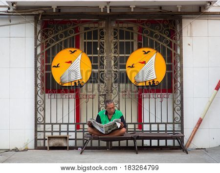 Semarang, Indonesia - september 13, 2015: Traditional street scene with man reading a newspaper in Semarang, Indonesia