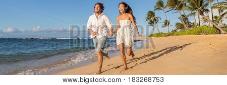 Happy couple relaxing running together on beach. Young multiracial people having fun during sunset on tropical vacation. Summer travel destination.