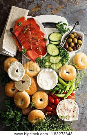 Big breakfast platter with cream cheese, bagels, smoked salmon and vegetables
