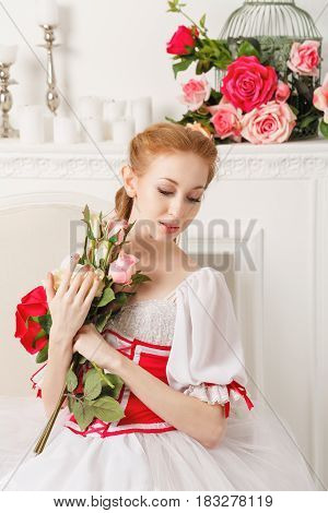 Sweet ballerina in a stage costume holds a bouquet of spring flowers. Retro dress. A gift from a fan.