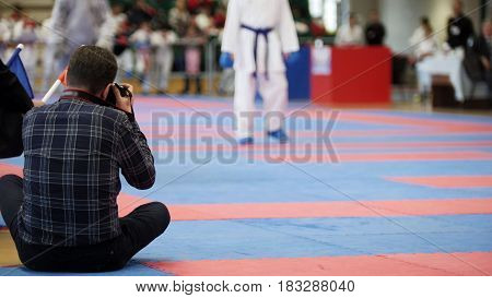 Photographers shoot during a karate competitions, telephoto