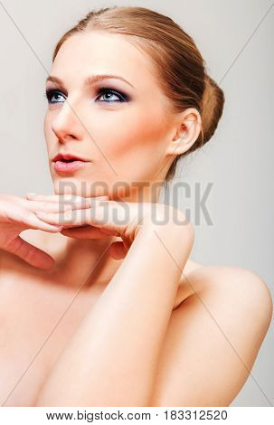 Attractive blonde topless woman with dark eye make up