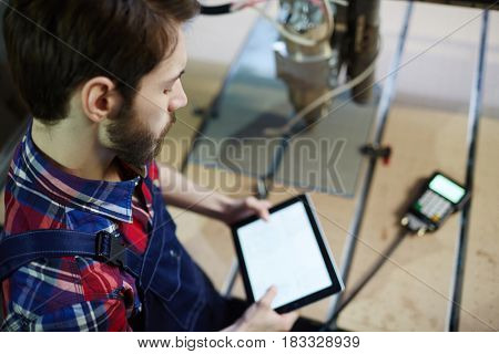 Young technician with touchpad at work