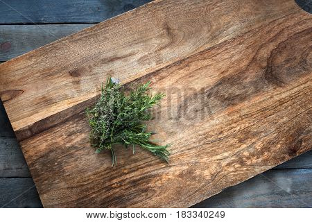 Fresh rosemary and thyme herbs on a cutting board