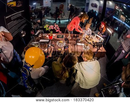 MOSCOW RUSSIA - APRIL 21 2017: Visitors take part in macro photography workshop at booth of Olympus company at PhotoForum 2017 trade show and exhibition in Moscow Russia on April 21 2017.