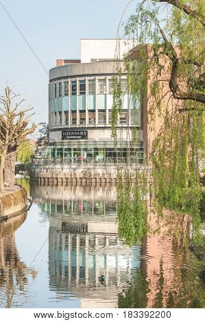 GUILDFORD, UK - APRIL 6: Early morning reflections of the Debenhams department store restaurant on the banks of the River Wey near Guildford, UK on April 6, 2017