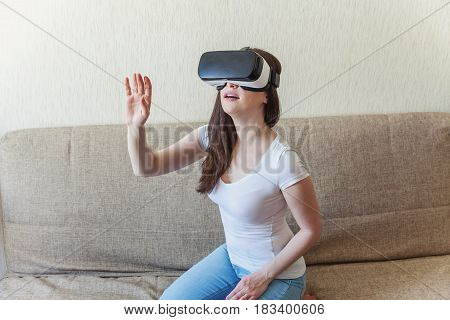 Smile happy woman getting experience using VR-headset glasses of virtual reality at home