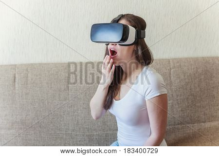 Smile happy woman getting experience using VR-headset glasses of virtual reality at home