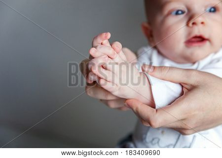 Playful cutie. Mother holding her newborn child. Family at home. Mom plays with her child