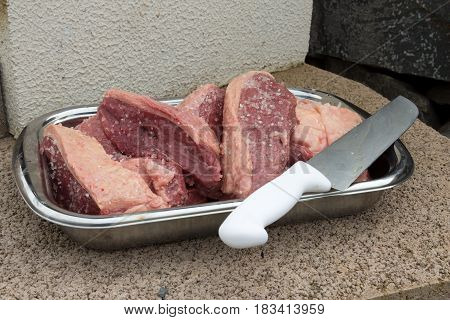 Pieces Of Picanha Brazilian Barbecue Beef With A Big Knife With White Handle On A Stainless Steel Bo