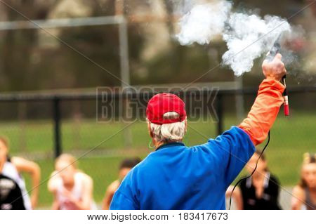 Smoke rises from the starters gun at the start of the 1500m race at a track compatition