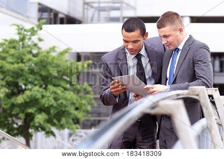Two Businessmen Discussing Document Outside his Office