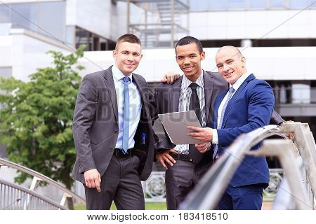 Three Businessmen Discussing Document Outside them Office