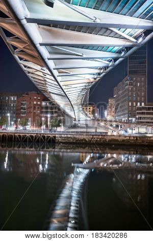 Bilbao cityscape and pedestrian zubizuri bridge at night Bilbao Basque country Spain.