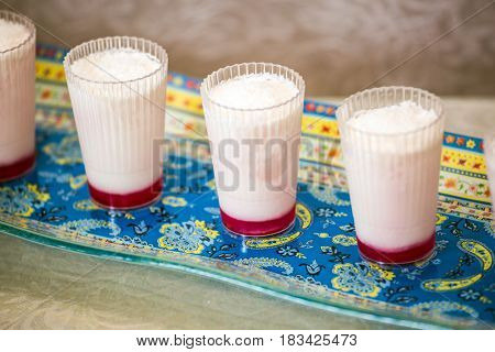 Malabi is the original Arabic delicacy. Sweet dessert with coconut.  Background - porcelain  patterned dish. Professional bakery