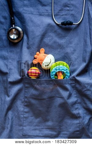 Pediatrics pocket with children toys on blue fabric background top view space for text