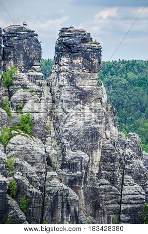 Alpinists on the top of relief camstone stones in Saxony national park, Bastai, Dresden, Germany.
