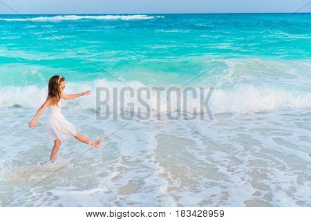 Adorable active little girl at beach during summer vacation
