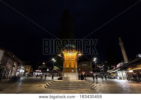 SARAJEVO BOSNIA HERZEGOVINA - APRIL 16 2017: Sebilj fountain on Bacarsija district at night. This fountain is considered to be one of the greatest landmarks of the Ottoman part of Sarajevo