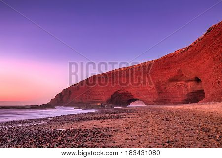 Sunset at red arches of Legzira beach, Sidi Ifni, Souss-Massa-Draa, Morocco.
