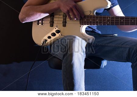 The Man Plays Bass Guitar On A Black Background, The Music Concept, Beautiful Lighting On The Stage