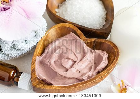 Spa setting. Cosmetic body And face mask made of pink clay sea salt towels and orchids.