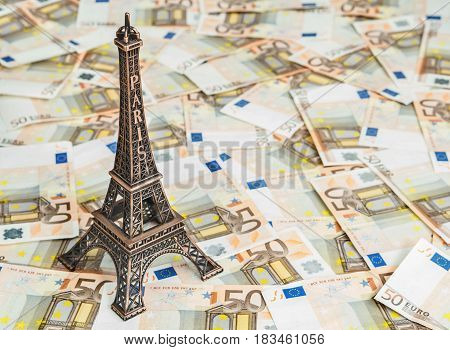Travel budget concept with copy space. Eiffel Tower souvenir and vacation money. Savings for trip to France.