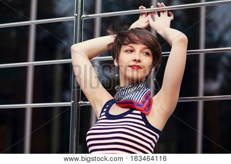 Happy young woman in city street. Stylish fashion model in tank top with pixie hairstyle outdoor