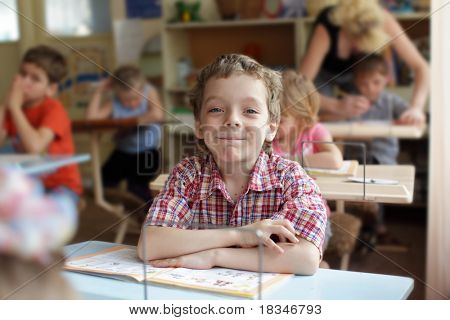 Smilende dreng i skoleklasse
