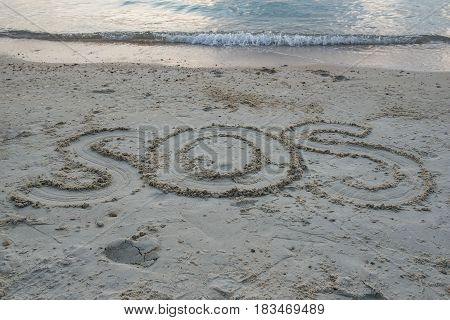 Word " SOS " Write in sand on the beach  .