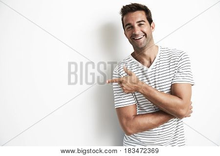Laughing dude in studio pointing portrait -white background with shadow