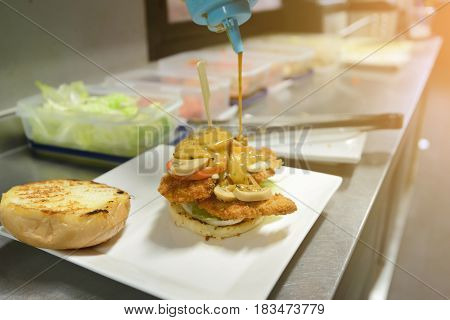 Chef Adding Sauce On Burger. Preparing Burger.