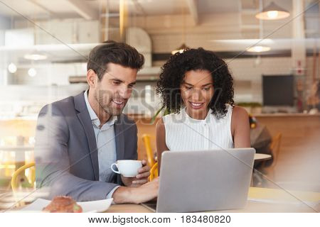 Two Businesspeople Meet In Coffee Shop Shot Through Window