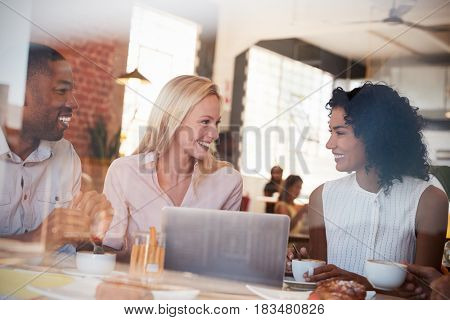 Businesspeople Meeting In Coffee Shop Shot Through Window