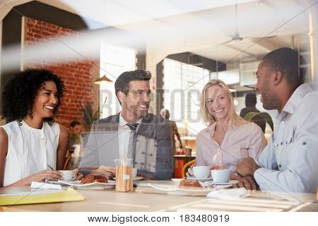 Businesspeople Meeting In Coffee Shop Shot Through Window
