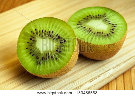 Healthy food. Tropical fruit. Whole and sliced kiwi. Kiwi fruit. Still life. Juicy kiwi on the wooden table