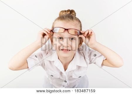 Funny Little Girl Wearing Eyeglasses Imitates A Strict Teacher Against White Background