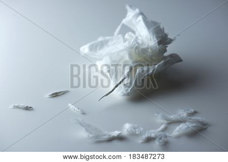 Very nervous. Crumpled, ripped and rolled tissue on a white table.?