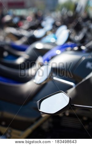 vertical detail row of parked motorcycles in the street selective focus
