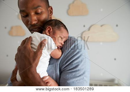 Father Holding Newborn Baby Son In Nursery