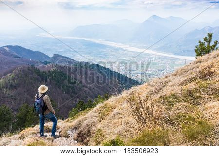 Hiker looking from Monte Chiampon to plain of Friuli-Venezia Giulia in Italy in spring