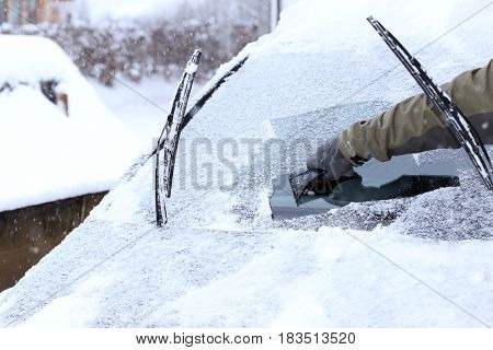 man is cleaning a wind screen of a car