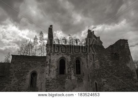 Church ruins in Chervonohorod or Chervone. Black-and-white image.Tourist with outstretched hands on building top.
