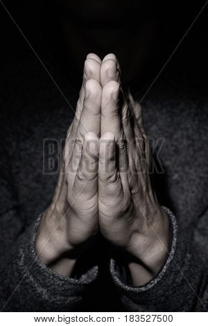 closeup of the hands of a young caucasian man praying with his hands put together